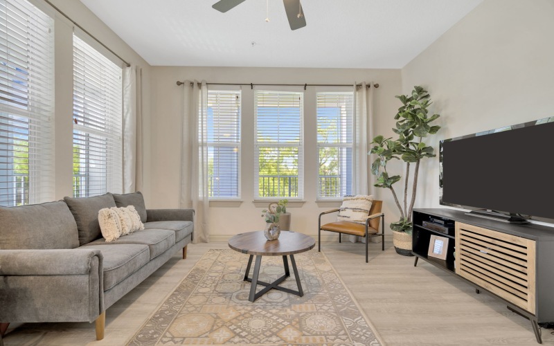 Living room with couch, lounge seats  with kitchen overlooking it