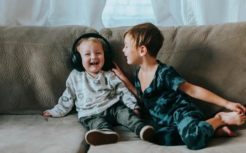 young brothers sit together on a large couch